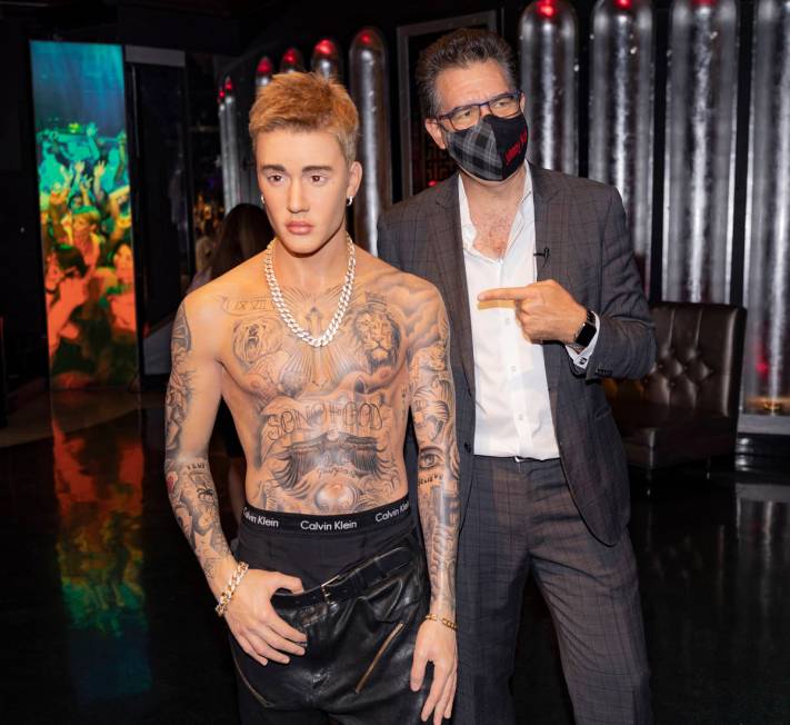 John Katsilometes is photographed with a wax figure of singer Justin Bieber during a tour of Ma ...