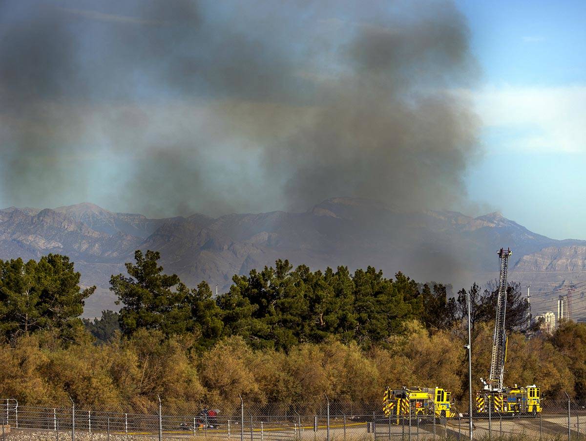 Clark County firefighters extinguish a brush fire in east Las Vegas near the Royal Links Golf C ...