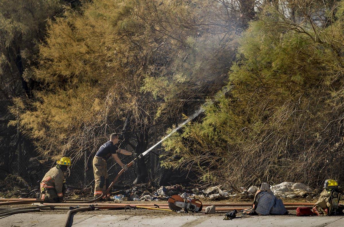 Clark County firefighters extinguish a brush fire in east Las Vegas near the Royal Links Golf C ...