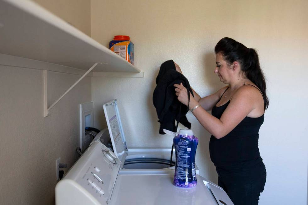 Alexis Cossman puts her work clothes, which she cleans after each shift to protect from coronav ...