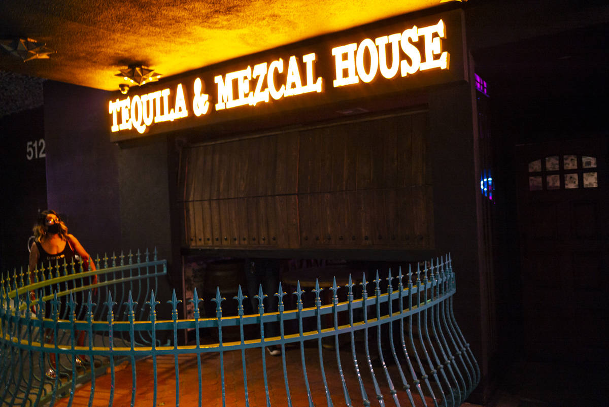 Employees lower the gate at Lucky Day Tequila and & Mezcal House on Fremont Street in downt ...