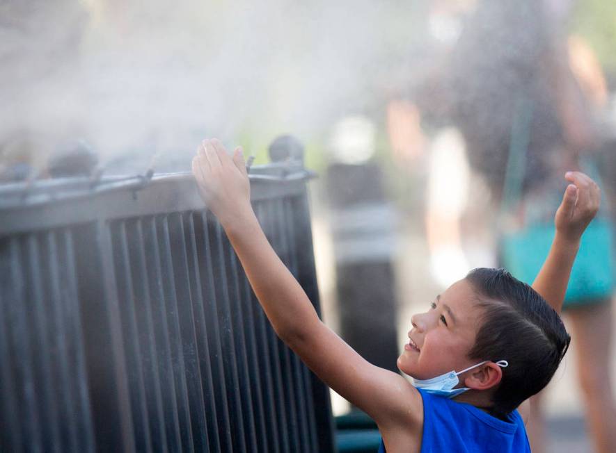 Brody Lester, 5, of California, cools off with the mist from HEXX kitchen + bar's patio as temp ...