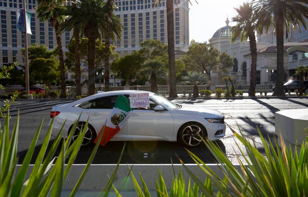 A car holds a sign saying "will fight for you Vanessa" as it drives down Las Vegas Boulevard on ...