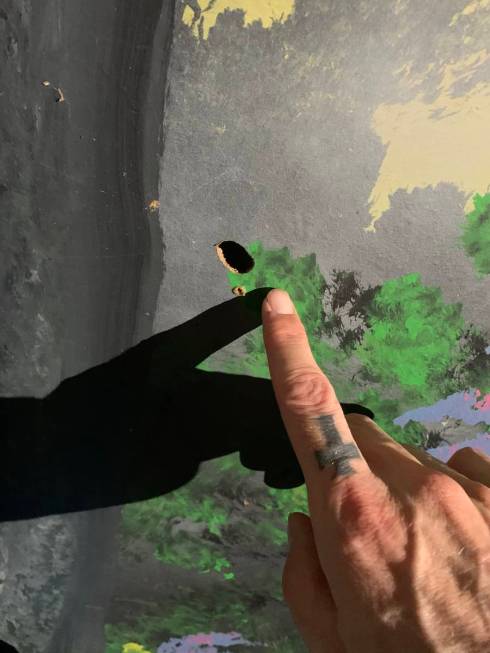 Zak Bagans points to a bullet hole at the scene of Travis Maldonado's suicide at Greater Wynnew ...