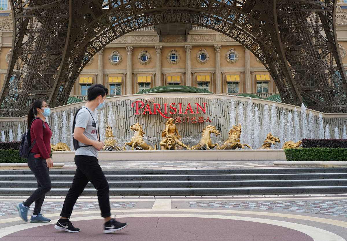 People walk past a replica Eiffel Tower outside the Parisian Macao on April 10, 2020. (Inside A ...