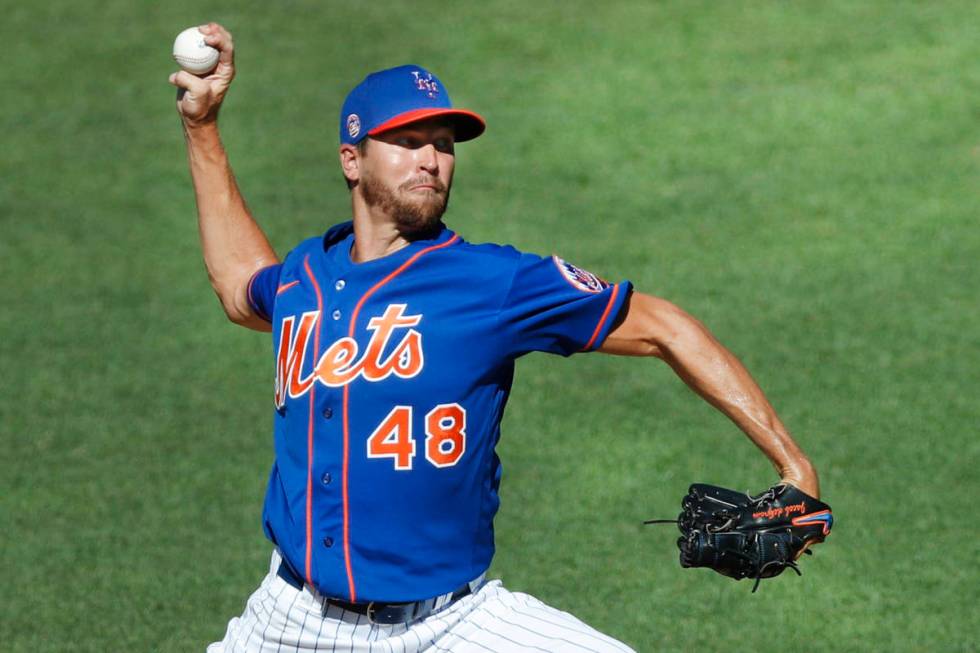 In this July 9, 2020, file photo, New York Mets starting pitcher Jacob deGrom winds up while de ...
