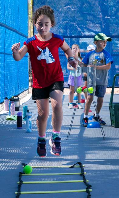 Lorelai Zimring, 7, jumps through obstacles at Camp Mustang at The Meadows School on Tuesday, J ...
