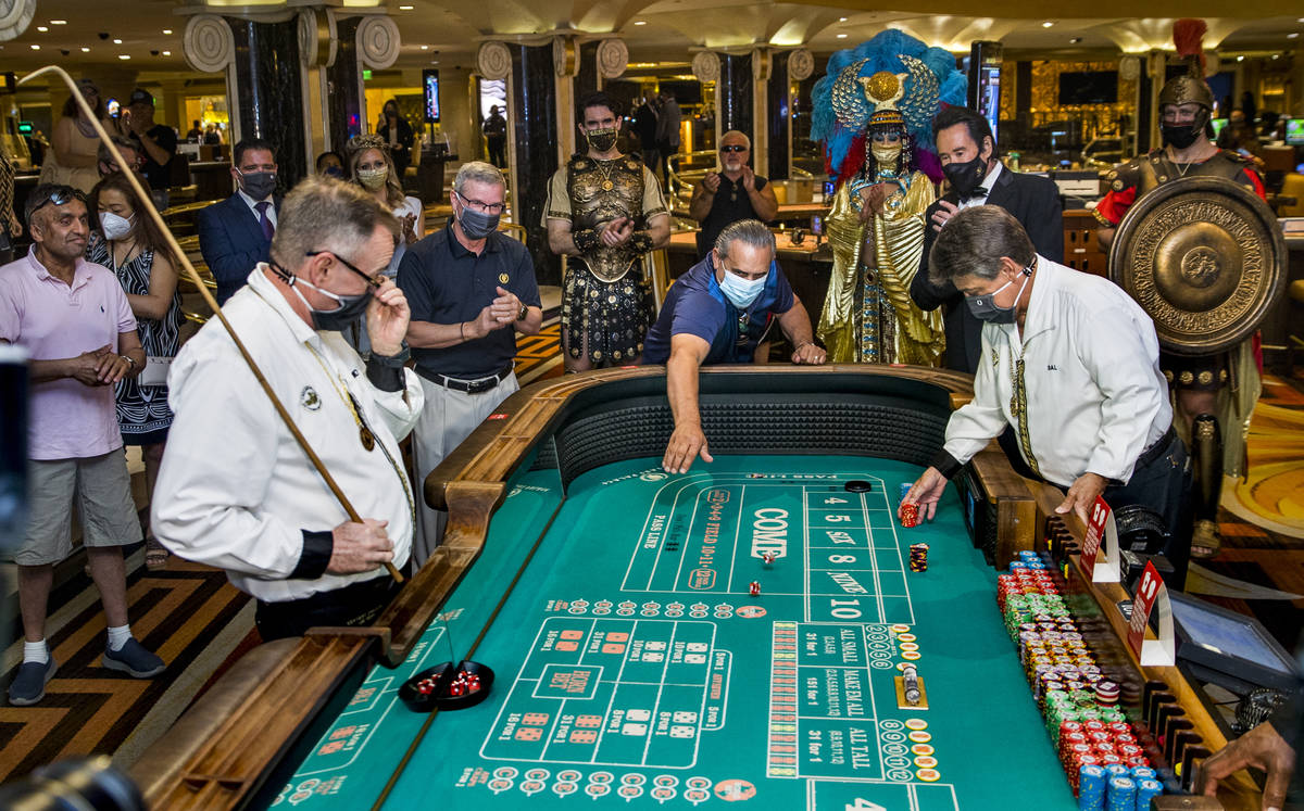 Guest Ben Laparne, center, throws the first dice at a caps table as part of the re-opening cere ...
