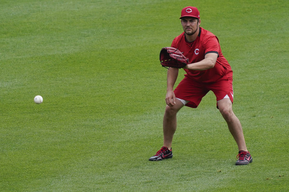 Cincinnati Reds pitcher Trevor Bauer warms up in the outfield during team baseball practice at ...