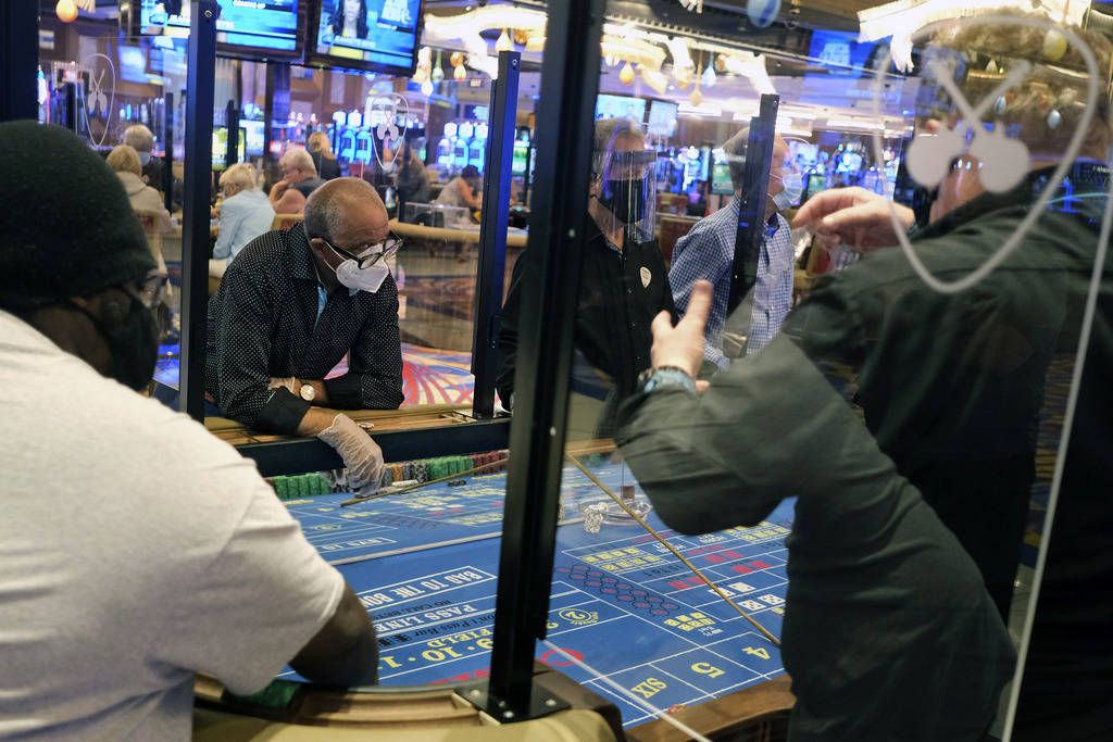 Partitions between players and face masks allow gamblers to enjoy craps at the Hard Rock Casino ...