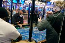 Partitions between players and face masks allow gamblers to enjoy craps at the Hard Rock Casino ...