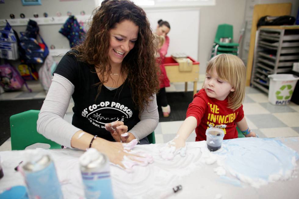 Teacher Bonnie Toth helps Sawyer Karadbil, 3, play with shaving cream in a game designed to dev ...