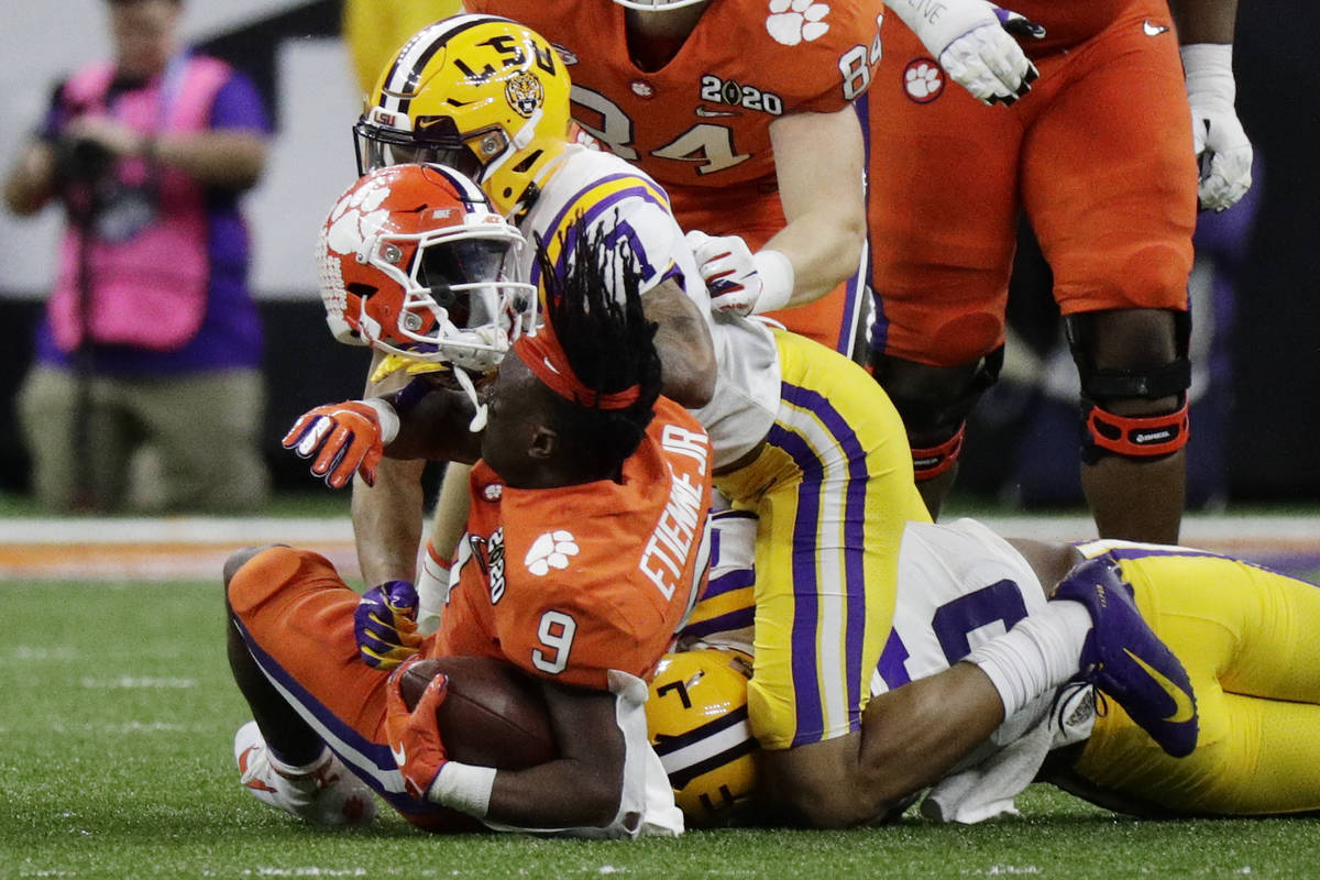 LSU safety Grant Delpit knocks the helmet off Clemson running back Travis Etienne during the fi ...