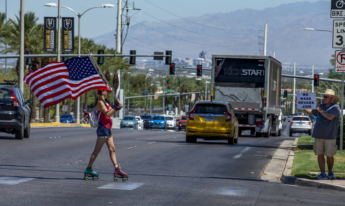 Christy Kettler roller skates with an American flag as others join in a No Mask Nevada PAC rall ...