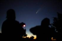 Local photography hobbyist Mike Alder, left, makes a long exposure images of the NEOWISE comet ...