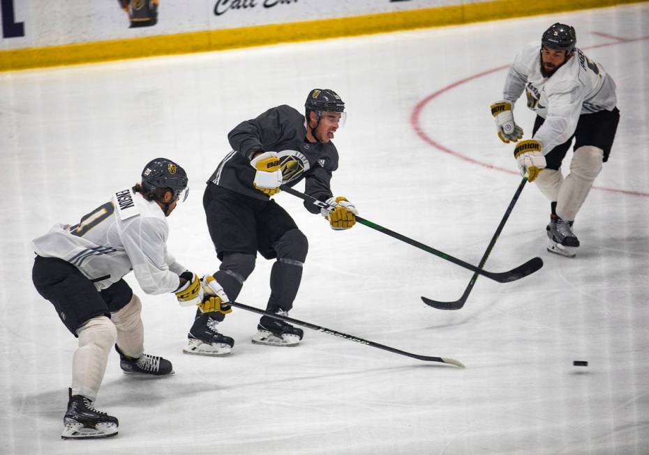 Golden Knights' Chandler Stephenson (20) and Deryk Engelland (5) try to block Reilly Smith (19) ...