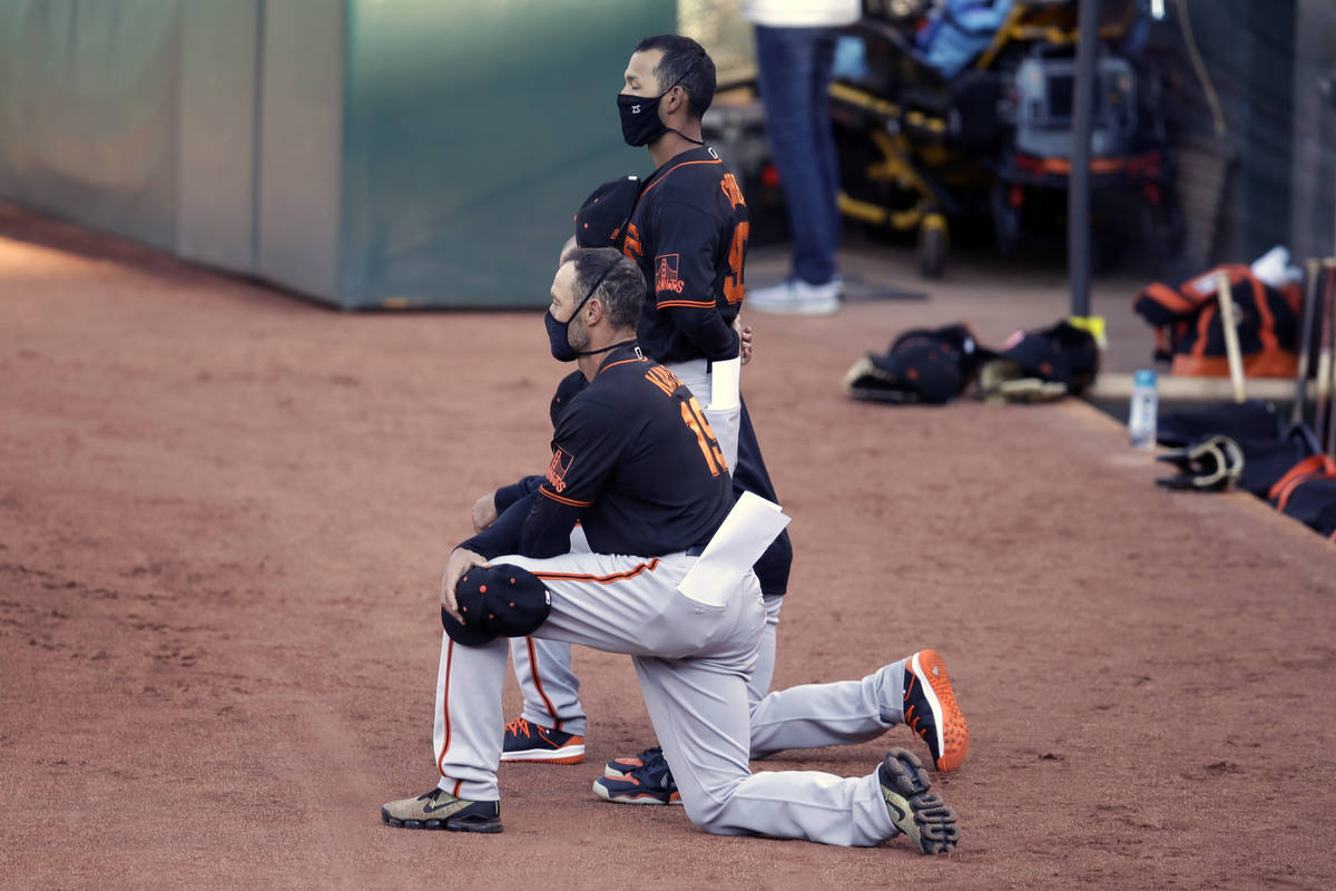 San Francisco Giants' manager Gabe Kapler kneels during the national anthem prior to an exhibit ...