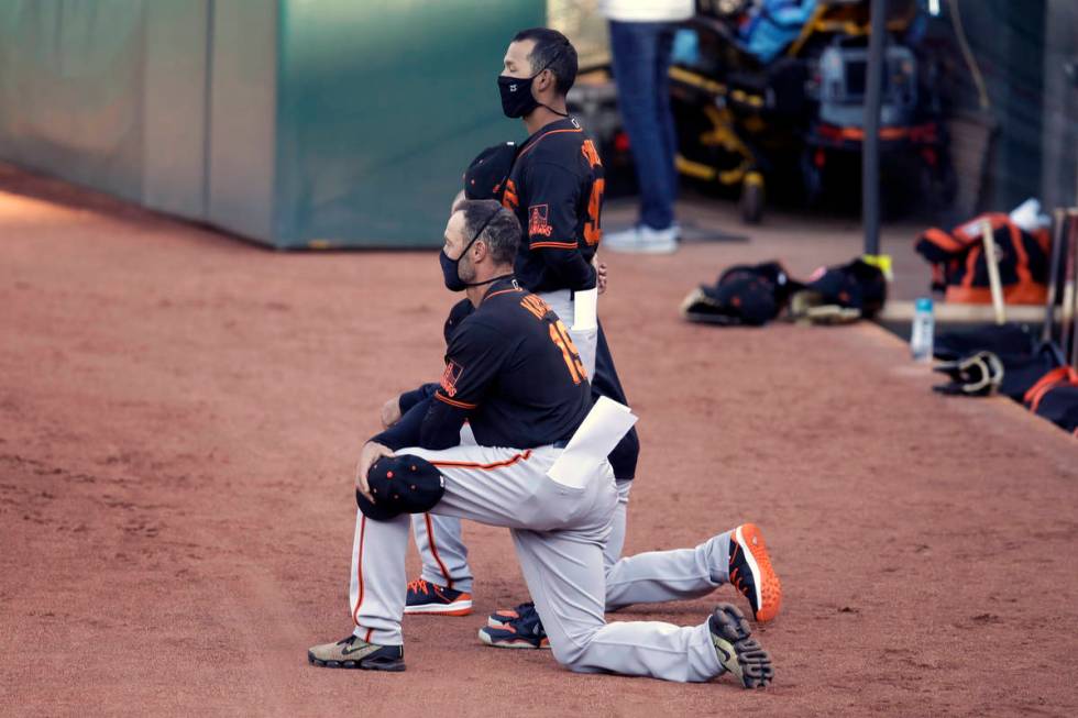 San Francisco Giants' manager Gabe Kapler kneels during the national anthem prior to an exhibit ...