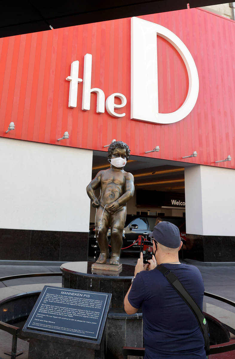 Avante Williams, a native of Detroit who now lives in Las Vegas, takes a photo of Manneken Pis ...