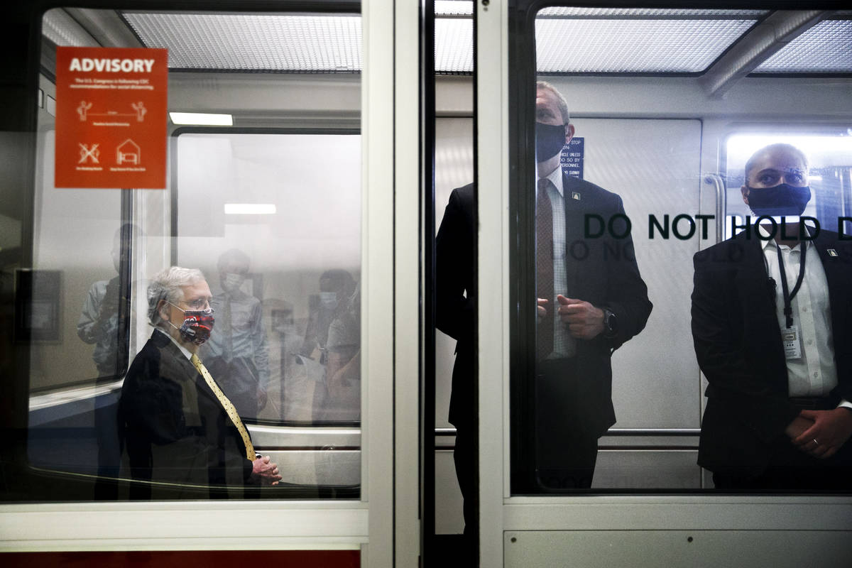 Senate Majority Leader Mitch McConnell of Ky., left, wears a mask for protection against the co ...