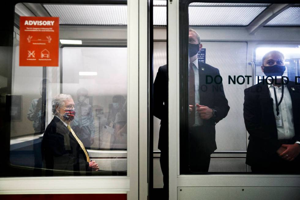 Senate Majority Leader Mitch McConnell of Ky., left, wears a mask for protection against the co ...