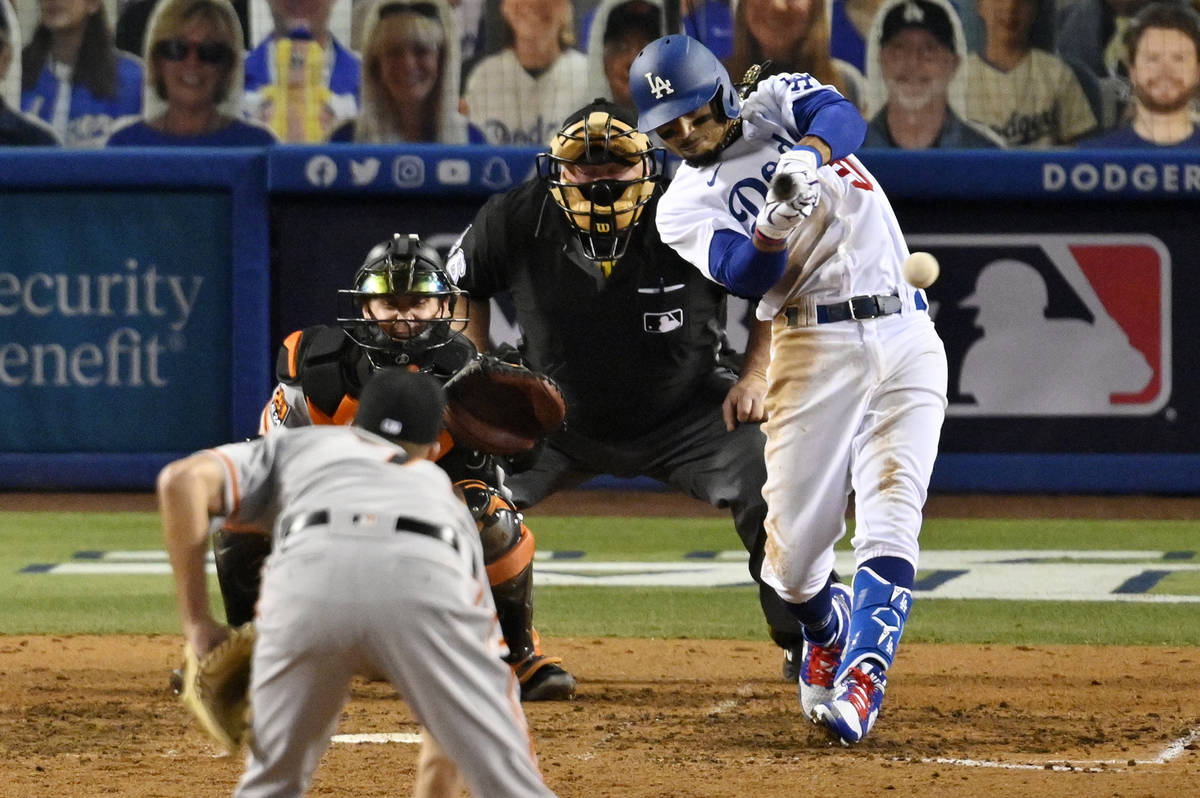 Los Angeles Dodgers' Mookie Betts, right, hits a single as San Francisco Giants relief pitcher ...