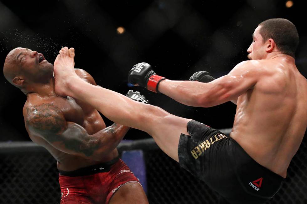 Robert Whittaker, right, kicks Yoel Romero in the face during their middleweight title mixed ma ...