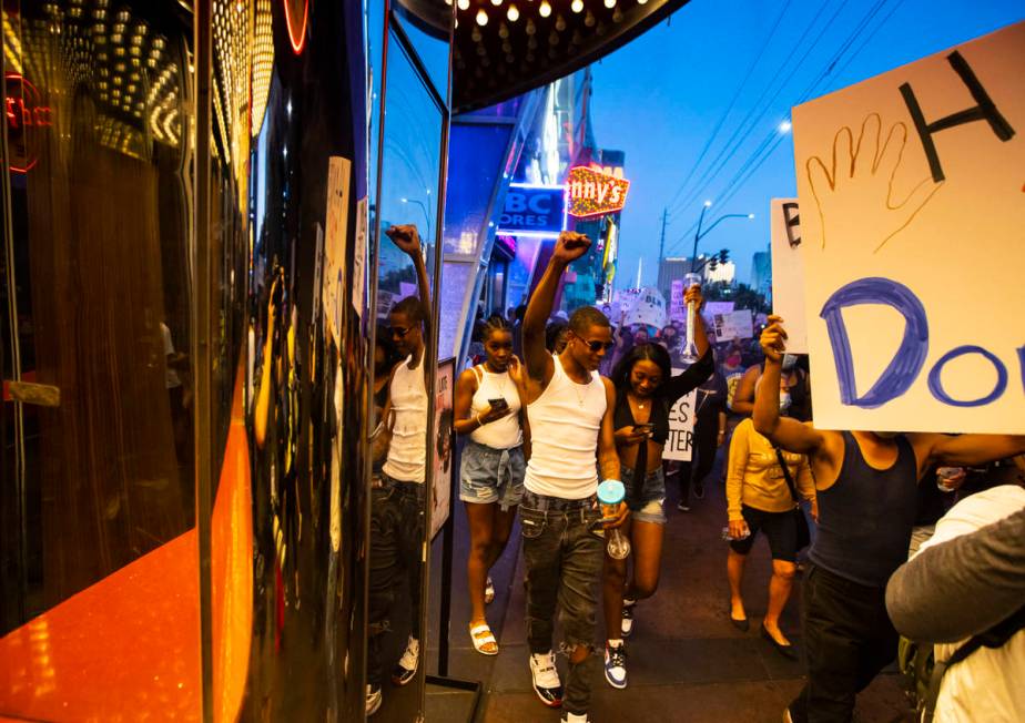 Tourists raise their fists in solidarity as people march during a Black Lives Matter rally on t ...