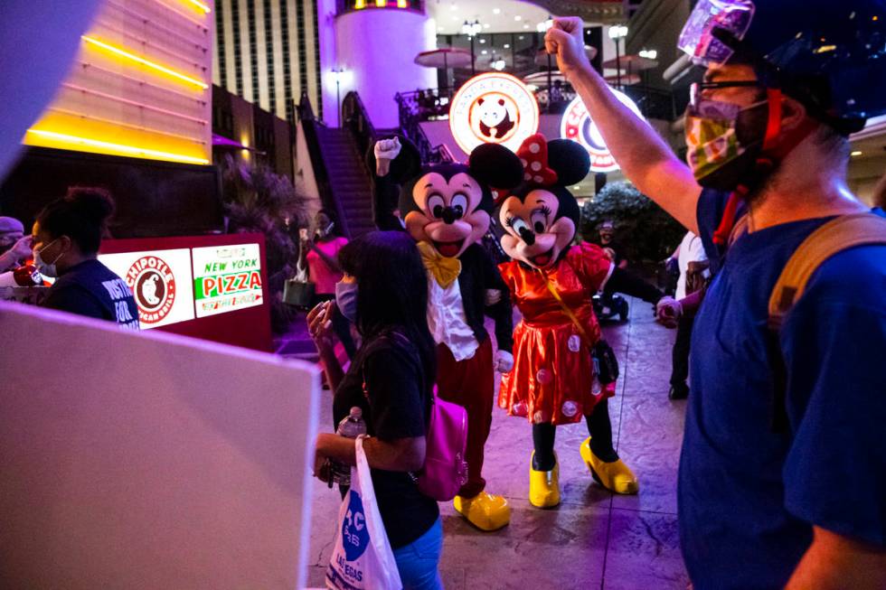 Street performers look as Black Lives Matter protesters walk on the Las Vegas Strip on Saturday ...