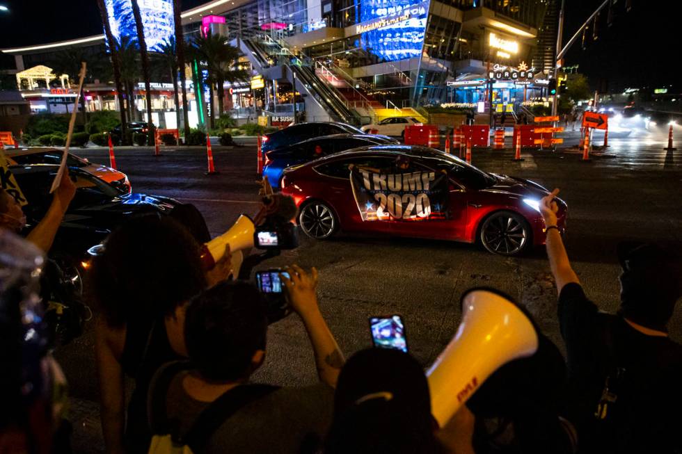 A man waves a "Trump 2020" flag shortly before the driver of the vehicle attempted to ...