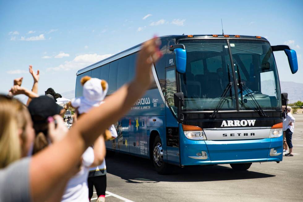 Fans wave at buses of the Golden Knights players as they leave for Canada as part of NHL's retu ...