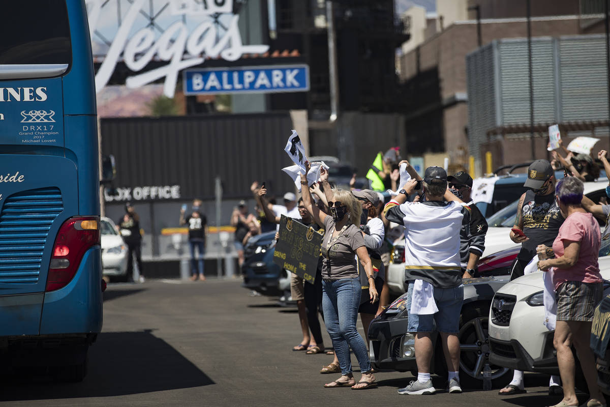 Fans wave at buses of the Golden Knights players as they leave for Canada as part of NHL's retu ...