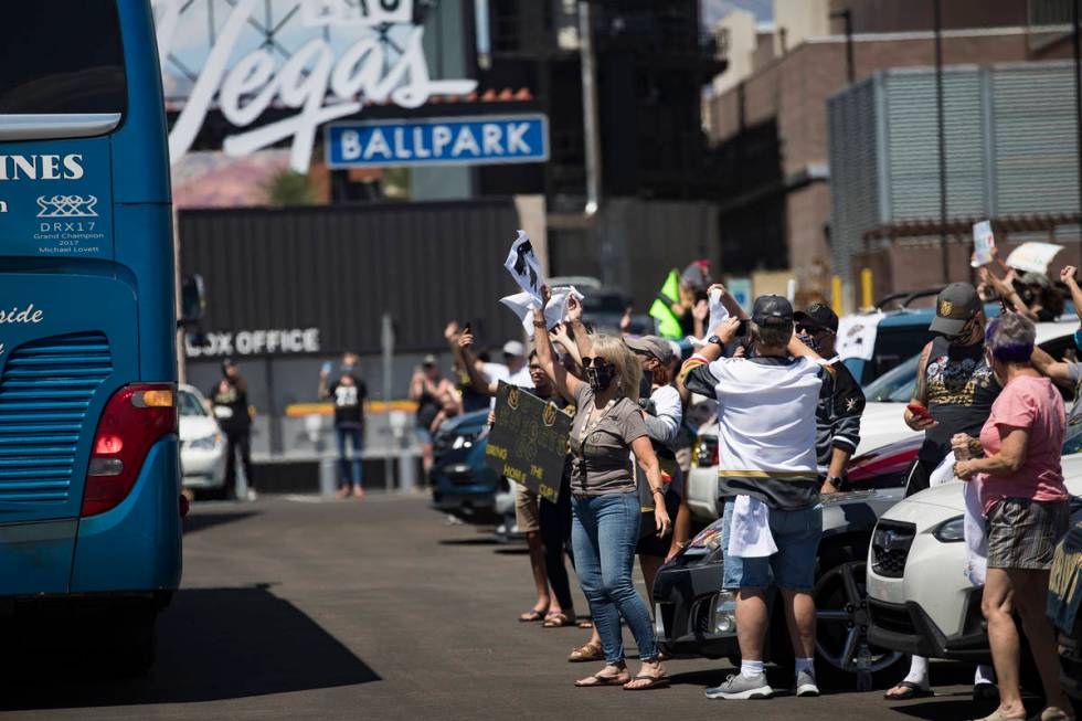 Fans wave at buses of the Golden Knights players as they leave for Canada as part of NHL's retu ...