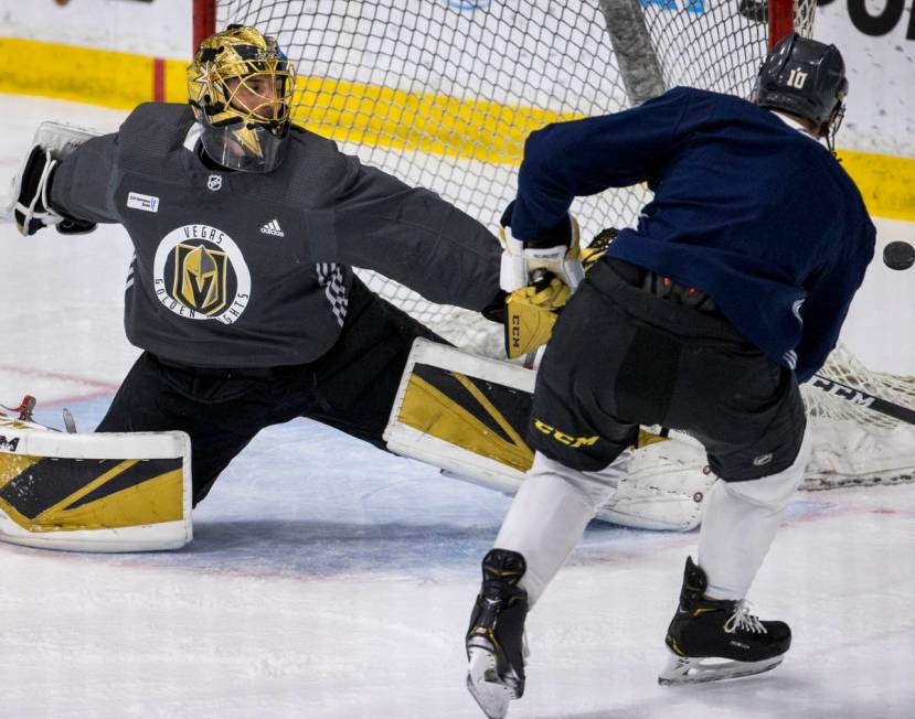 Vegas Golden Knights goaltender Marc-Andre Fleury (29, left) deflects away a shot by center Nic ...