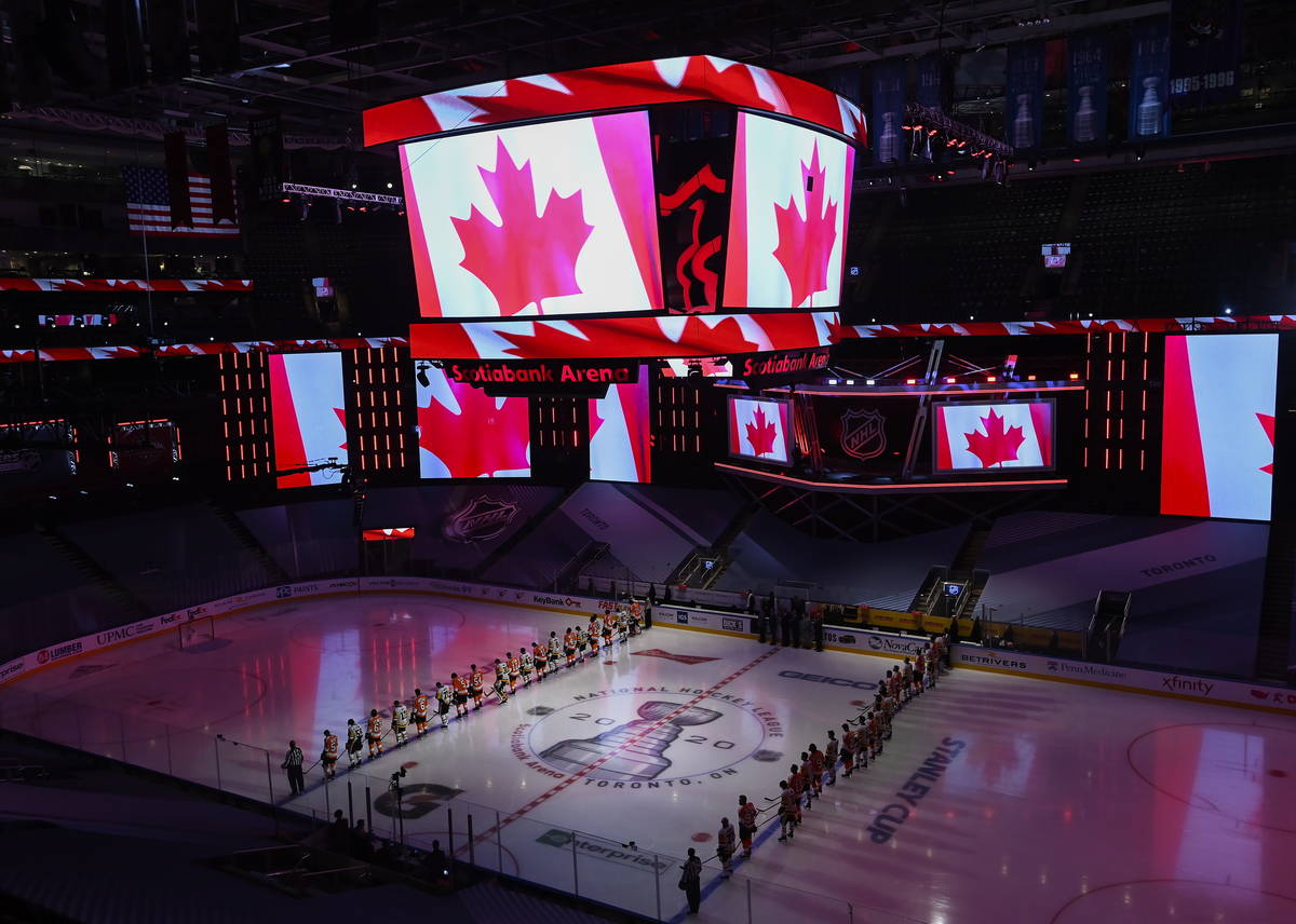 The Pittsburgh Penguins and Philadelphia Flyers line up together for the national anthems befor ...