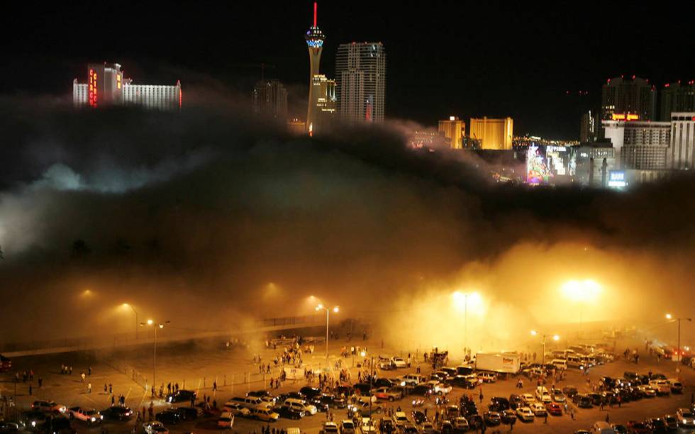 A cloud of dust from the Stardust hotel-casino rolls over spectators and media in the Frontier ...