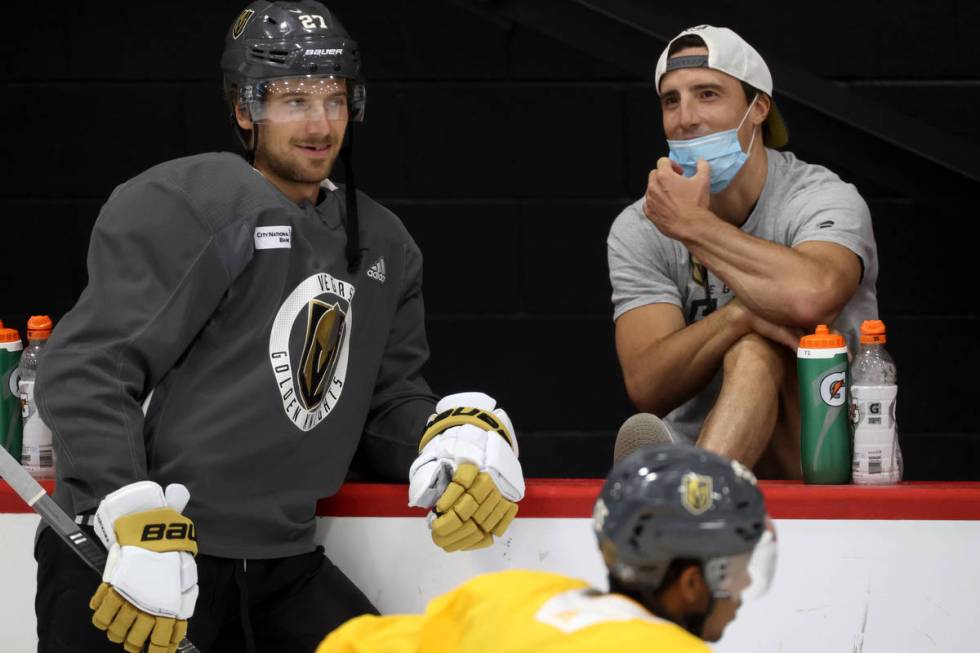 Vegas Golden Knights defenseman Shea Theodore (27), left, talks to Vegas Golden Knights goalten ...