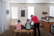 Atticus Mayville, 7, left, and Everett Mayville, 7, work on school projects with help from thei ...
