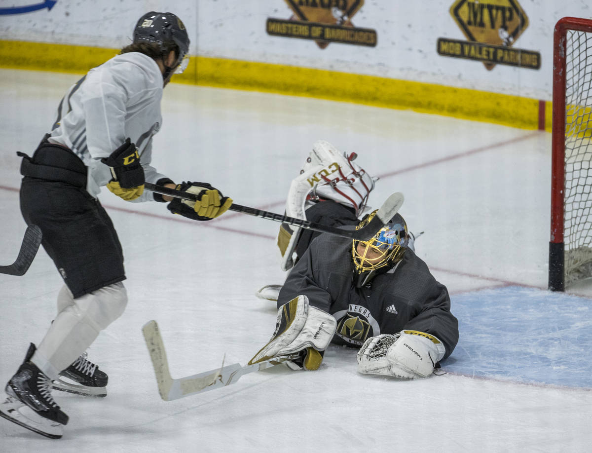 Vegas Golden Knights center Chandler Stephenson (20, left) has a shot stopped by diving goalten ...