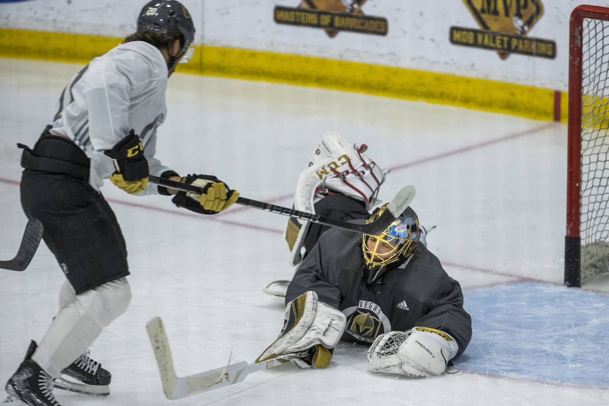 Vegas Golden Knights center Chandler Stephenson (20, left) has a shot stopped by diving goalten ...