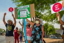 Gig workers gather with signs and wave to passing motorists to protest the Nevada unemployment ...