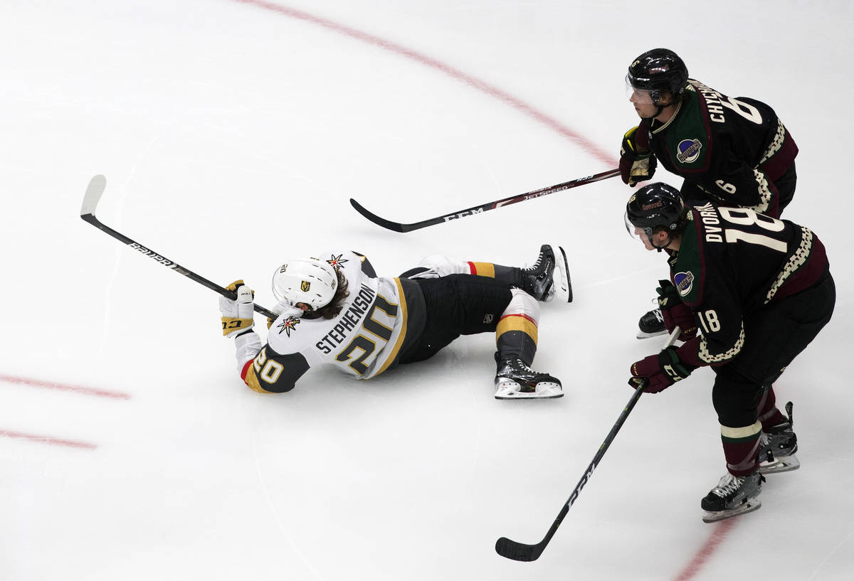 Arizona Coyotes' Christian Dvorak (18) and Jakob Chychrun (6) trip up Vegas Golden Knights' Cha ...