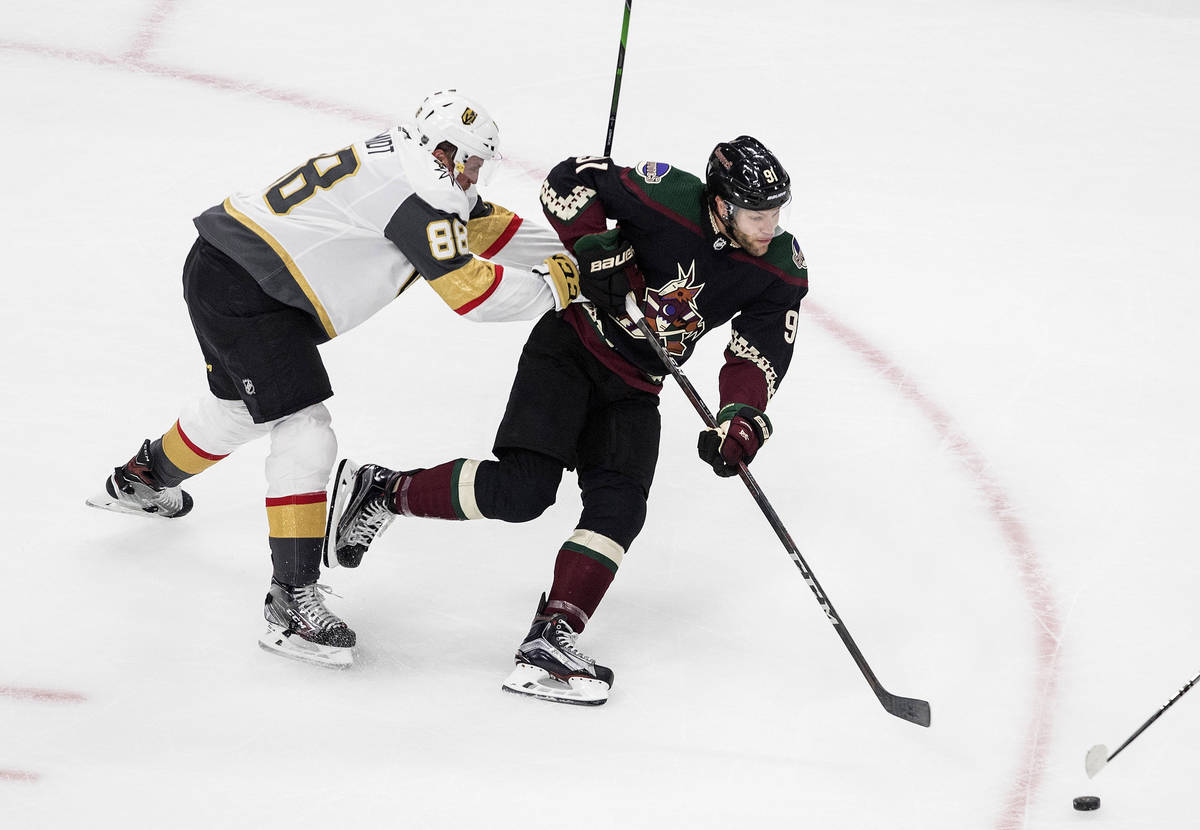 Arizona Coyotes' Taylor Hall (91) is checked by Vegas Golden Knights' Nate Schmidt (88) during ...