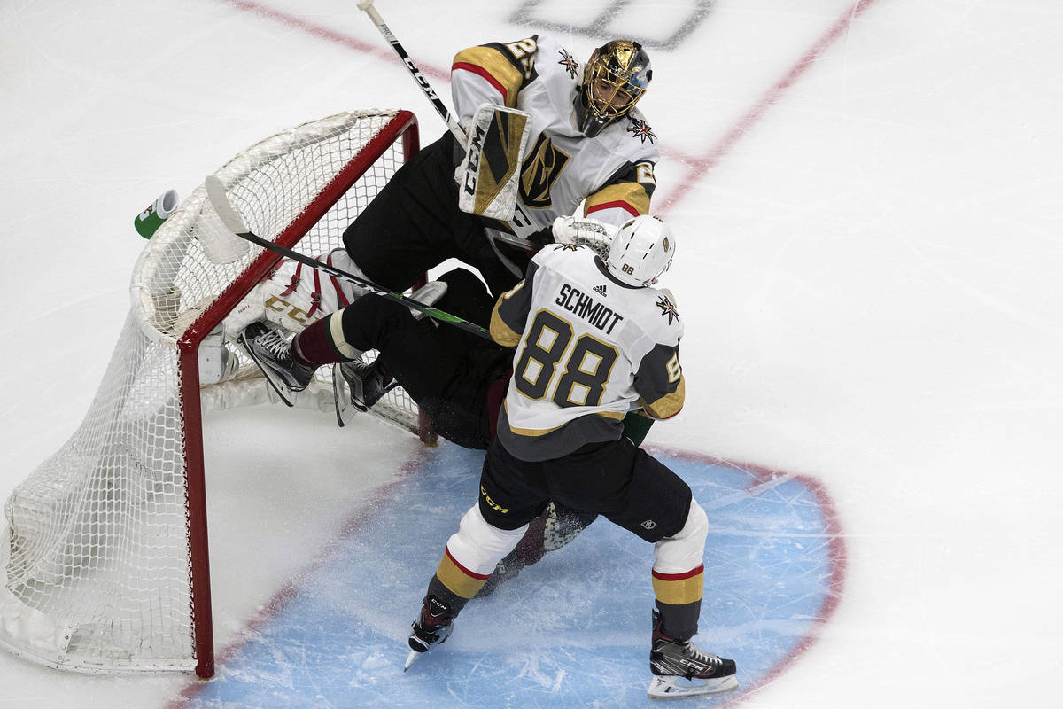 Arizona Coyotes' Taylor Hall (91) crashes into Vegas Golden Knights goalie Marc-Andre Fleury (2 ...