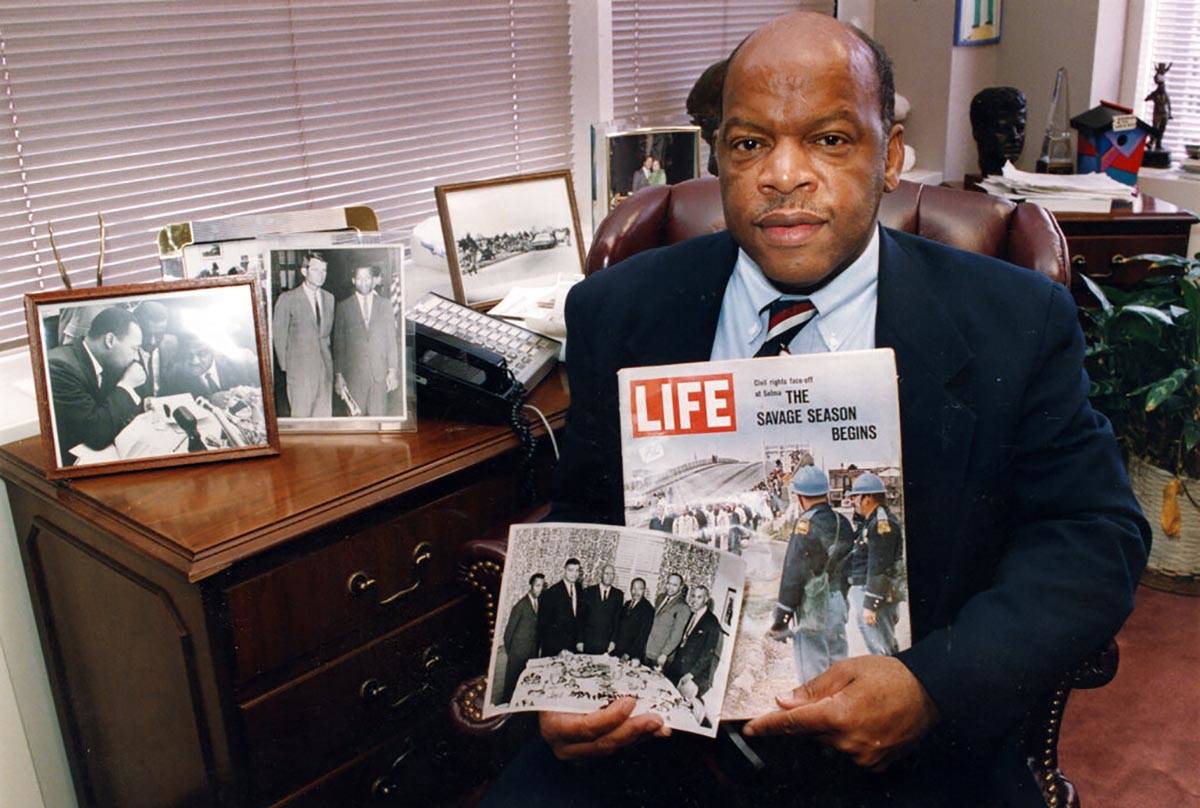 Congressman John Lewis poses in his Atlanta office with two of his favorite items from his coll ...