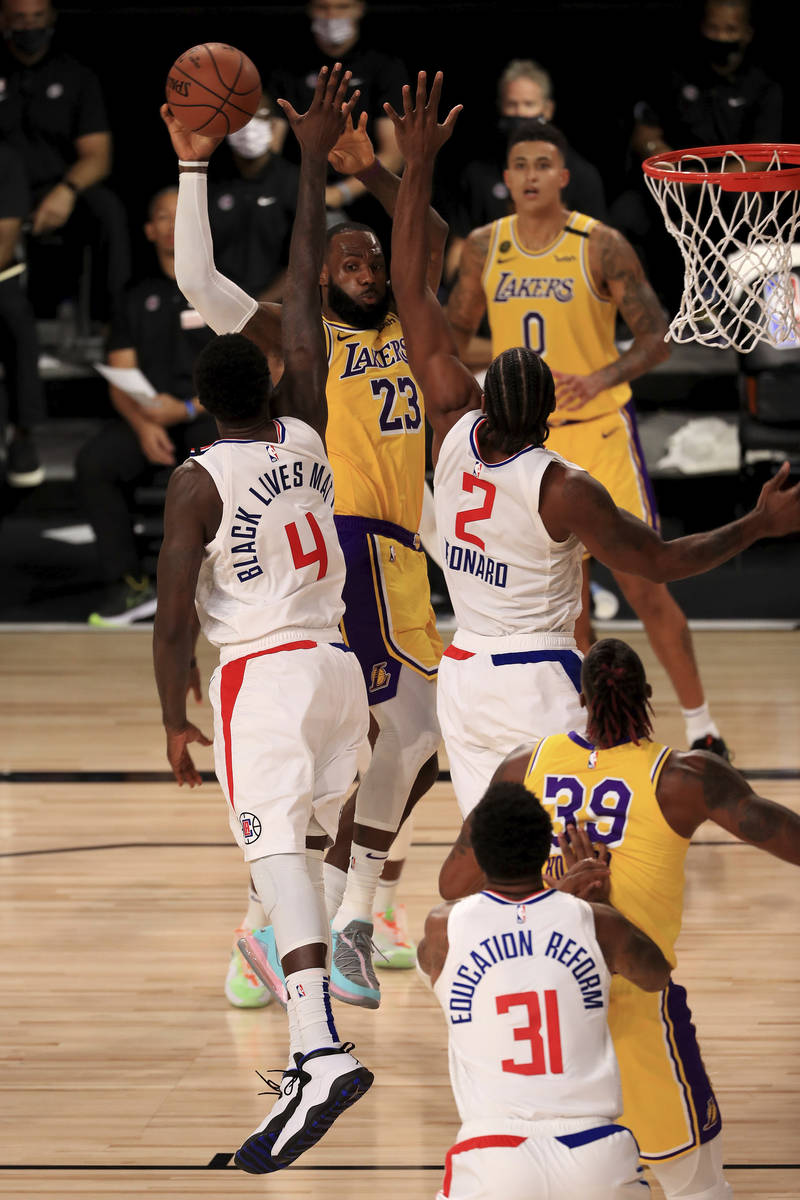 Los Angeles Lakers' LeBron James (23) is defended by Los Angeles Clippers' JaMychal Green (4) a ...
