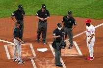 FILE - In this Friday, July 24, 2020, file photo, home plate umpire Tim Timmons, center, explai ...