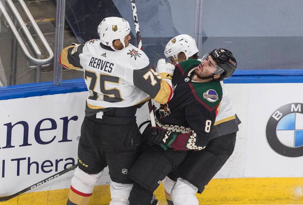 Arizona Coyotes' Nick Schmaltz (8) is checked by Vegas Golden Knights' Ryan Reaves (75) and Zac ...