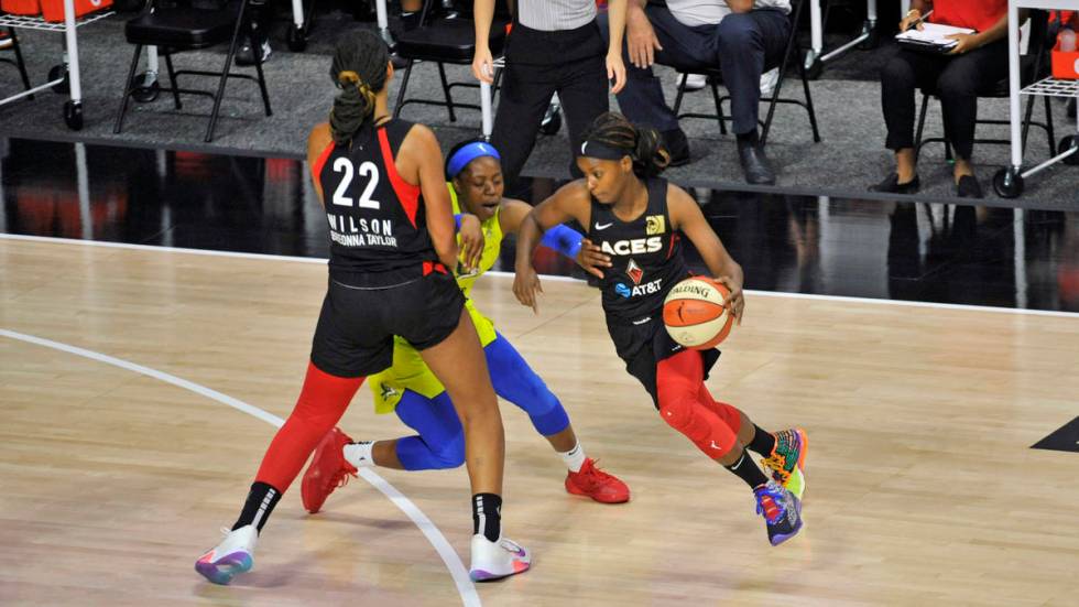 Las Vegas Aces' A'ja Wilson (22) blocks Dallas Wings' Arike Ogunbowale, center, as Aces' Sugar ...