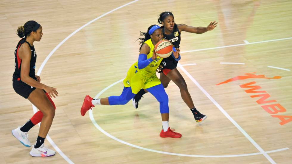 Dallas Wings' Tyasha Harris, center, moves between Las Vegas Aces' A'ja Wilson, left, and Jacki ...